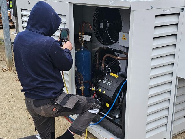 Workman repair a commercial refrigeration unit