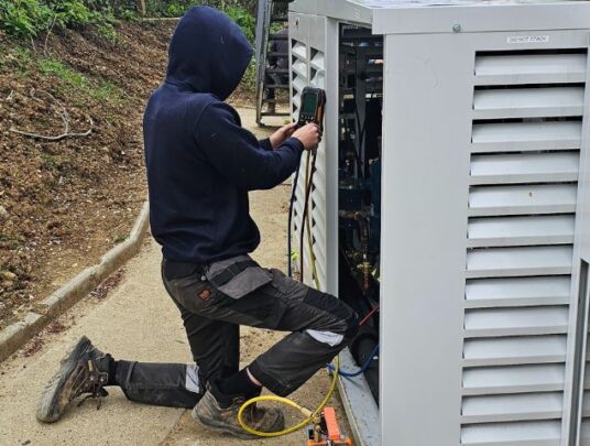 Workman repairing an outside refrigeration unit