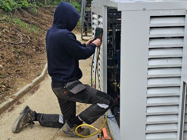 Workman repairing an outside refrigeration unit